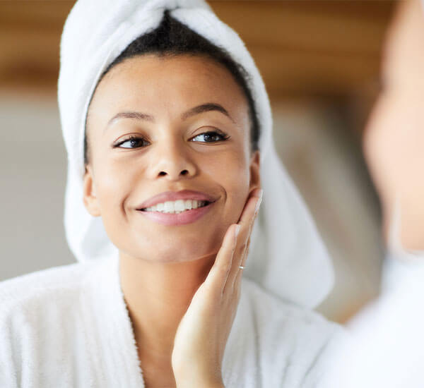 Woman touching her skin after premium facial rejuvenation at California LASIK and Eye