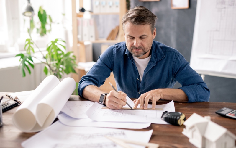 man working on architectural drawings